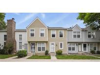 Charming townhome featuring tan siding, complemented by well-maintained landscaping and a welcoming entryway at 8879 W Floyd Ave, Lakewood, CO 80227