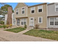 Charming townhome featuring a well-maintained lawn, neutral siding, and inviting entryway at 8879 W Floyd Ave, Lakewood, CO 80227