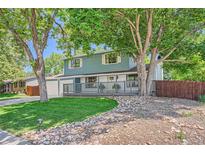 Charming two-story home featuring a covered porch, mature trees, and a well-maintained front yard at 6494 W 85Th Ave, Arvada, CO 80003