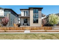 Charming two-story home with a stone facade, balcony, manicured lawn and inviting curb appeal at 6054 N Perth St, Aurora, CO 80019