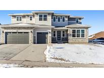 Two-story house with gray siding, stone accents, and a three-car garage at 4993 Hickory Oaks St, Castle Rock, CO 80104