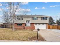 Ranch style home with brick and siding exterior, attached garage, and landscaped yard at 7636 S Eaton Way, Littleton, CO 80128