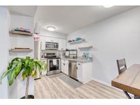 Well-lit kitchen features stainless steel appliances, gray granite countertops, and modern white cabinetry at 5300 E Cherry Creek South Dr # 804, Denver, CO 80246