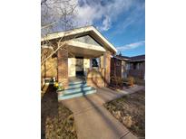 Charming brick home featuring a covered front porch with brick pillars and freshly painted stairs at 3336 N Saint Paul St, Denver, CO 80205