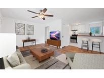 Inviting living room with hardwood floors, ceiling fan, and bar seating into the kitchen at 6765 W 33Rd Ave, Wheat Ridge, CO 80033