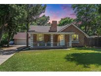 Charming brick home with a lush front lawn and a welcoming porch, perfect for relaxing outdoors at 11940 W Independence Ave, Lakewood, CO 80401