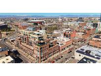 Stunning aerial view of a modern brick building complex in a vibrant city with distant mountain views at 1499 Blake St # 3M, Denver, CO 80202