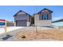 Beautiful front of this home showcasing a modern exterior, a two car garage and xeriscaping at 8555 Hotchkiss St, Littleton, CO 80125
