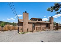 Two story home featuring a private entrance, chimney, and a spacious driveway for convenient parking at 30819 Hilltop Dr, Evergreen, CO 80439