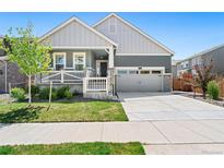 Charming home featuring a well-manicured lawn, gray two-car garage door, and inviting front porch at 872 S Flat Rock Way, Aurora, CO 80018