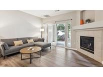 Inviting living room with fireplace, wood floors, and sliding glass doors at 9692 W Coco Cir # 103, Littleton, CO 80128