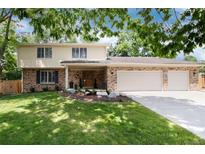 Charming two-story brick home with a three-car garage and well-manicured lawn at 9837 E Aberdeen Ave, Englewood, CO 80111