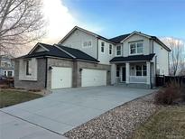 Charming two-story home featuring a three-car garage, covered porch, and professional landscaping at 3231 Lump Gulch Way, Erie, CO 80516