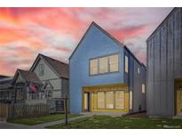 Modern two-story home featuring blue siding and large windows beneath a colorful, vibrant sky at 3725 N Franklin St, Denver, CO 80205