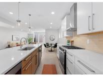 Bright, open kitchen with stainless steel appliances, white countertops, and a dining area at 3725 N Franklin St, Denver, CO 80205