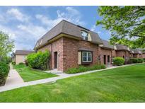 Charming brick townhouse with well-manicured lawn and mature landscaping, creating a welcoming curb appeal at 5547 S Lowell Blvd, Littleton, CO 80123