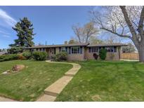 Charming single story home with a well-manicured lawn and inviting walkway at 180 Dover St, Lakewood, CO 80226