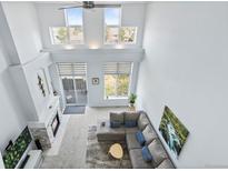 Bright living room boasts soaring ceilings, fireplace, oversized windows, and a comfortable sectional sofa at 3425 W 111Th Loop # B, Westminster, CO 80031
