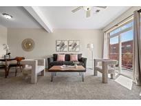 Stylish living room featuring modern decor and a sliding door to a private balcony at 7883 W 55Th Ave, Arvada, CO 80002