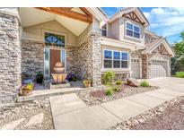 Charming stone-accented facade with meticulously landscaped front yard and relaxing water feature at 23965 E Kettle Pl, Aurora, CO 80016