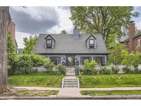 Charming two-story home with dormer windows, white picket fence, and well-manicured lawn at 824 S Medea Way, Denver, CO 80209