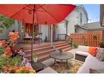 Relaxing backyard patio featuring a large red umbrella, seating area and colorful flowers at 5161 S Emporia Way, Greenwood Village, CO 80111