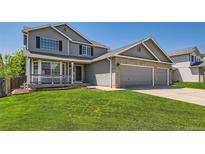 Charming gray two-story home with manicured lawn and brick accents on a sunny day at 11034 W Aqueduct Ln, Littleton, CO 80127