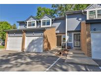 Townhouse exterior featuring a gray facade, attached garage, and landscaping at 1695 Carr St # B, Lakewood, CO 80214