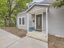 Charming home featuring a covered front door with glass detailing and light gray wood siding at 5339 S Windermere St, Littleton, CO 80120