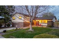Charming two-story home with a well-manicured lawn and beautiful landscaping and an attached garage at 7290 Lamar Ct, Arvada, CO 80003