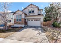 Inviting home showcasing a wide driveway, two-car garage, neutral stucco and stone accents at 4542 Valleybrook Dr, Highlands Ranch, CO 80130