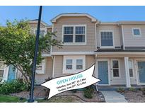 Inviting multi-level townhouse with neutral siding, pretty landscaping, and a charming blue front door at 18954 E 57Th Pl # D, Denver, CO 80249