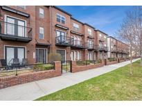 Brick townhome complex with black wrought iron railings and balconies, fronted by green lawns and sidewalks at 4108 W 118Th Pl, Westminster, CO 80031