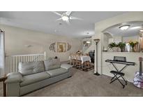 Open-concept living room featuring a comfortable sofa and seamless access to the dining area and staircase at 479 Black Feather Loop # 311, Castle Rock, CO 80104