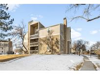 Inviting condo building with balconies and a stone chimney on a snow-covered lawn at 4896 S Dudley St # 6-5, Littleton, CO 80123