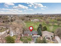 Expansive home with lush green lawn with the city skyline in the distance at 930 Reed Ct, Lakewood, CO 80214