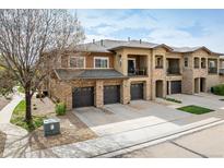 Beautiful townhome featuring stone accents, a private balcony, and attached garages at 1122 Olympia Ave # 12H, Longmont, CO 80504