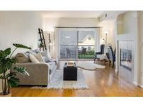 Bright living room with wood floors, a fireplace, and sliding glass doors to a balcony at 1122 Olympia Ave # 12H, Longmont, CO 80504