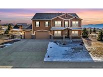 Charming two-story home with a three-car garage and landscaped front yard at 1235 Woodmoor Acres Dr, Monument, CO 80132