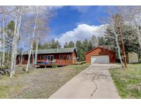Charming cabin home with a spacious driveway and detached garage nestled in a forest setting at 26367 Pressler St, Conifer, CO 80433