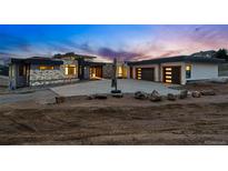 Stunning modern home featuring a stone facade and three-car garage with a spacious driveway at 545 Strada Rossa Rd, Golden, CO 80401