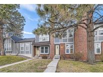 Brick townhouse with a green door and walkway at 1233 S Flower Cir # D, Lakewood, CO 80232