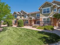 Beautifully landscaped townhomes with well-manicured lawn, stone accents, and inviting entrances on a sunny day at 3662 S Perth Cir # 104, Aurora, CO 80013