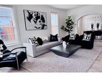 Bright living room featuring a modern sofa, accent chairs, contemporary art, and neutral decor at 1517 W Nevada Pl, Denver, CO 80223