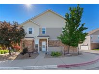 Charming multi-story home with stone and siding exterior, complemented by mature trees and a well-maintained lawn at 12784 Jasmine St # E, Thornton, CO 80602