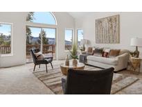 Bright living room with large windows, stylish furniture, and beautiful mountain views and modern decor at 1580 Santa Fe Mountain Rd, Evergreen, CO 80439