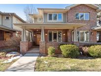 Brick two-story home with a covered porch and landscaped yard at 1907 S Columbine St, Denver, CO 80210