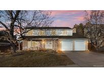 Two-story house with attached two-car garage, landscaping, and a tree in the front yard at 5875 E Weaver Cir, Centennial, CO 80111