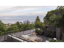 Relaxing rooftop deck with an outdoor grill and comfortable seating offering stunning city views at 4817 W 10Th Ave, Denver, CO 80204