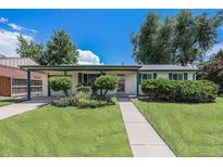 Charming single-story home with a well-manicured lawn, covered porch, and mature trees creating curb appeal at 5502 E Center Ave, Denver, CO 80246